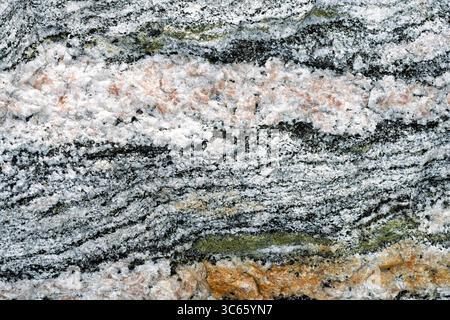 Intricate textures of a natural rock formation exhibit various mineral patterns and colors, creating a captivating geological display. Stock Photo