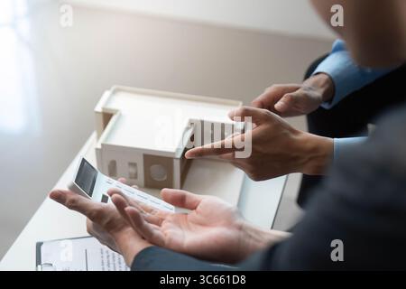 Design Presentation. Architects discussing building model and project specifications. Stock Photo