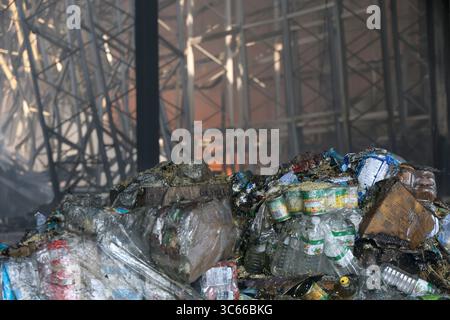 The bottles of water and canned food are damaged by the fire in a warehouse caused by a Russian missile attack, Vasyshcheve, Kharkiv region, Ukraine, July 30, 2025. At around 12:00 local time on Wednesday, July 30, Russian troops fired two S-300/S-400 missiles at Vasyshcheve settlement, according to preliminary data. The strike hit a distribution centre that housed three corporations, including a grocery supermarket, killing a security guard and injuring five other citizens. A large fire broke out at the location of the strike. Three employees of the State Emergency Service were injured while Stock Photo
