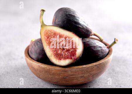 Fresh figs in a wooden bowl on a gray background. Stock Photo