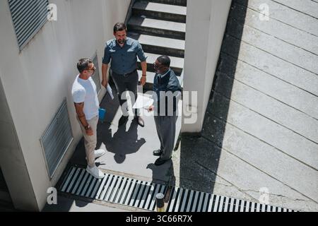 Group of professionals having a discussion outdoors near a modern building Stock Photo