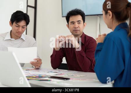 UX and UI Team Discussion. Professionals collaborating on mobile app design concepts. Stock Photo