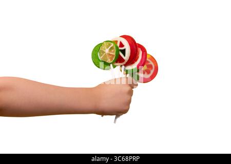 Child’s hand holding colorful fruit lollipops, isolated on white background for clean and versatile design use. Stock Photo