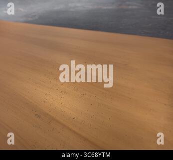 Close up of brass surface. Textured brass piece on grey stone wall - selective focus Stock Photo