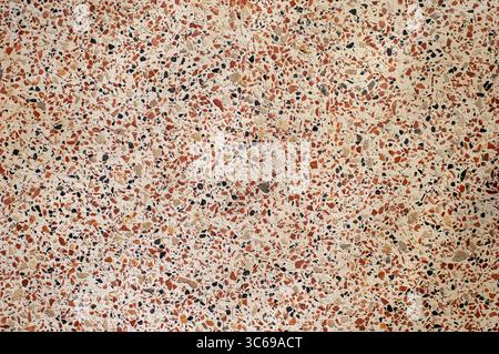 Full frame background texture of classic polished terrazzo floor with red black and beige marble chips. Stock Photo