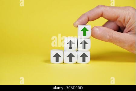 White cubes growing graph arranged in upward sequence with arrows icon pointing up symbolizing business success, consistent development and growth. Stock Photo