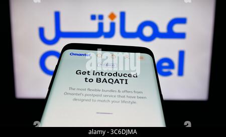 Stuttgart, Germany - 06-20-2025: Mobile phone with website of Oman Telecommunications Company (Omantel) on screen in front of logo. Stock Photo