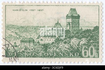 CZECHOSLOVAKIA - 1957 February 23: 60 haléř deep rose postage stamp depicting view of Karlštejn (Karlstein) Castle in the Czech Republic. It is a large Gothic castle founded in 1348 by King Charles IV. The castle served as a place for safekeeping the Imperial Regalia as well as the Bohemian Crown Jewels, holy relics, and other royal treasures. Karlštejn is among the most famous and most frequently visited castles in the country. Karlštejn Castle is situated on a hill overlooking the Berounka river and the market town proper, roughly 30 km (19 mi) southwest of the capital city of Prague Stock Photo