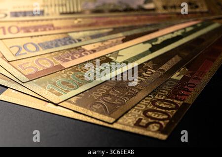 A close-up image showcasing a fanned arrangement of Euro banknotes of different denominations, captured against a black backdrop, emphasizing wealth, Stock Photo