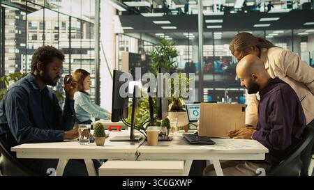 Manager giving company bookkeeper business documents to read and verify accuracy Employee analyzing company information records provided by supervisor in office, camera B Stock Photo