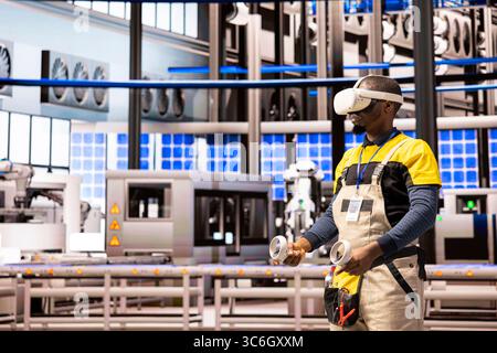 Black male engineer in smart photovoltaics facility tracking system performance with artificial intelligence. Industry 4.0 expert using VR and IoT sensors, overseeing production in automated factory. Stock Photo