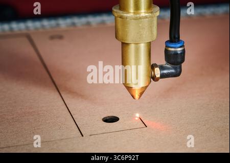 Precision laser cutting process in a cardboard box manufacturing facility showcasing innovative technology and craftsmanship Stock Photo