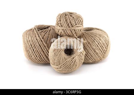 Four spools of natural twine are arranged against a clean white background, presenting a crafting and DIY aesthetic. Perfect for various projects. Stock Photo