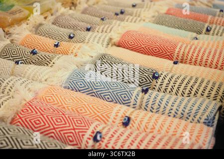 Colorful Rolled Cotton Fabrics with Geometric Patterns Displayed in Rows Stock Photo