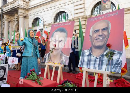 Rome, Italy. 30th July, 2025. Maryam Rajavi is seen raising her fist in solidarity beside portraits of recently executed MEK supporters Mehdi Hassani and Behrouz Ehsani during an exhibition. The NCRI organized an exhibition and memorial ceremony at Piazza dei Santi Apostoli in Rome to honor victims of executions and repression in Iran. Maryam Rajavi, President-elect of the NCRI, joined the Iranian diaspora in laying flowers and commemorating the lives of MEK martyrs, including recently executed political prisoners Behrouz Ehsani and Mehdi Hassani. Credit: SOPA Images Limited/Alamy Live News Stock Photo