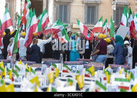 Rome, Italy. 30th July, 2025. Maryam Rajavi joins Iranian Resistance supporters surrounded by flags and banners honoring fallen protesters during the outdoor memorial. The NCRI organized an exhibition and memorial ceremony at Piazza dei Santi Apostoli in Rome to honor victims of executions and repression in Iran. Maryam Rajavi, President-elect of the NCRI, joined the Iranian diaspora in laying flowers and commemorating the lives of MEK martyrs, including recently executed political prisoners Behrouz Ehsani and Mehdi Hassani. Credit: SOPA Images Limited/Alamy Live News Stock Photo