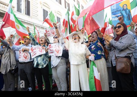 Rome, Italy. 30th July, 2025. Iranian diaspora women are seen chanting and raising flags during the NCRI-led demonstration and exhibition. The NCRI organized an exhibition and memorial ceremony at Piazza dei Santi Apostoli in Rome to honor victims of executions and repression in Iran. Maryam Rajavi, President-elect of the NCRI, joined the Iranian diaspora in laying flowers and commemorating the lives of MEK martyrs, including recently executed political prisoners Behrouz Ehsani and Mehdi Hassani. (Photo by Siavosh Hosseini/SOPA Images/Sipa USA) Credit: Sipa USA/Alamy Live News Stock Photo