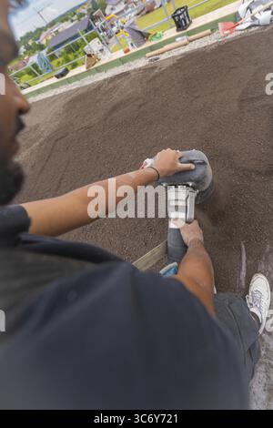 Close-up of a worker using a tool on a floor, roof greening, house construction, climate neutral Stock Photo