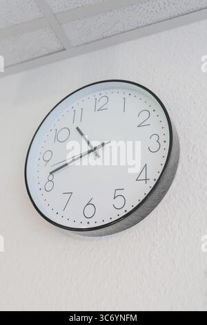 Round wall clock with white dial and black hands, Care Connect, vaccination kiosk for refugees, Calw, Germany Stock Photo