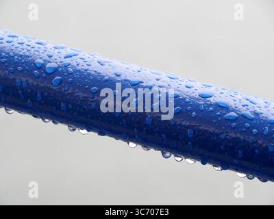 Raindrops on blue railing Stock Photo