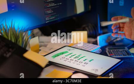 Checklist digital tablet task management workspace. Modern tech desk with digital tablet displaying handwritten to-do list, surrounded by coding monit Stock Photo
