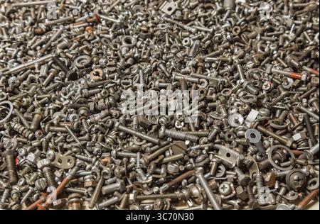 Many different small bolts, nuts, washers, grovers, studs and screws. Technical background. Industrial texture. Stock Photo