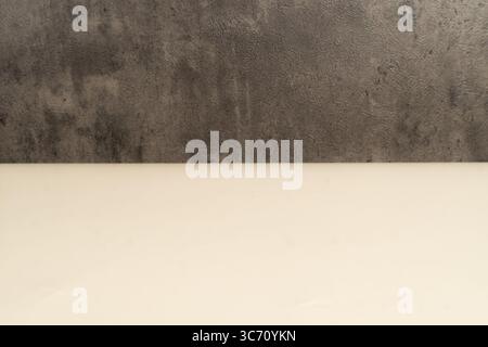 Neutral background featuring light beige surface and dark concrete wall texture. Ideal for product mockups, banner designs, presentations. Stock Photo