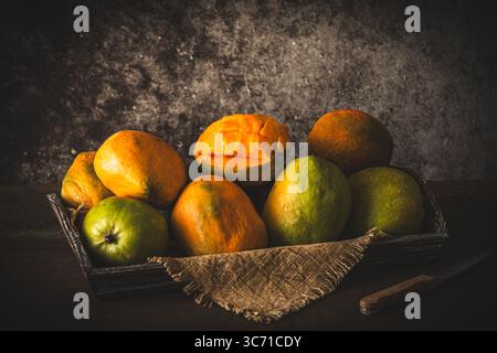 Mangoes of different ripeness and colors on a wooden tray, copy space Stock Photo
