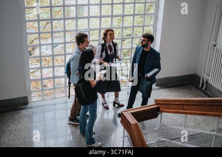 Students engaging in discussion with professor in university hall Stock Photo