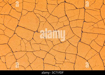 Orange cracked paint distressed background. Grunge peeling paint texture. Stock Photo