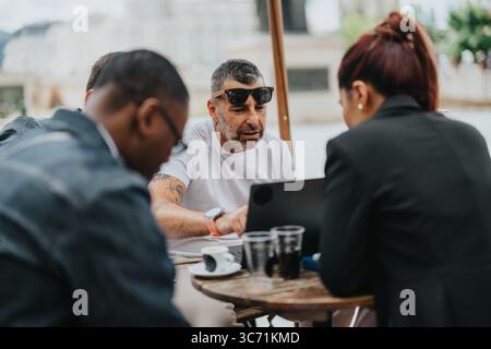 Multiracial team collaborating during an outdoor business meeting in a casual setting Stock Photo