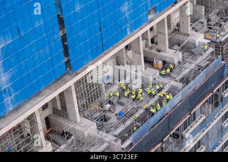 Bangkok, Thailand - 20 December 2024: Construction workers on site at high-rise building Stock Photo