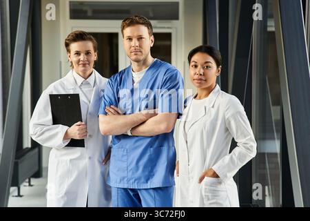Three doctors, a black woman and two others, work together in a contemporary hospital setting. Stock Photo