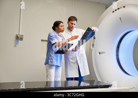 Two doctors collaborate on an MRI scan in a state-of-the-art hospital environment. Stock Photo