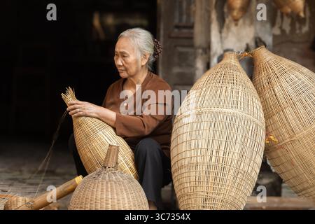 Traditional bamboo trap makers at work, preserving a centuries-old craft Stock Photo