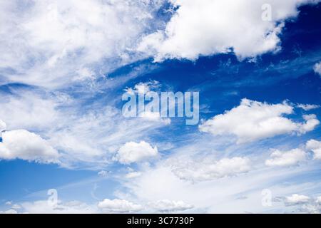 Bright blue sky filled with soft, white, and wispy clouds. Stock Photo