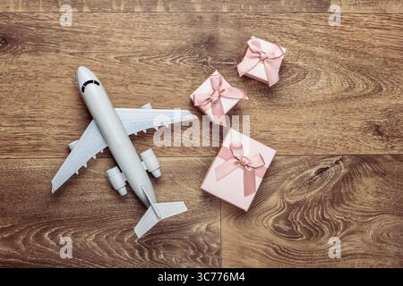 Air delivery. Plane figurine and gift boxes on floor. Flat lay. Top view Stock Photo