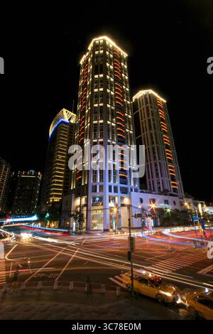Stunning night view capturing the illuminated skyscrapers and bustling crossroads near Banqiao Train Station in New Taipei City, with light trails fro Stock Photo