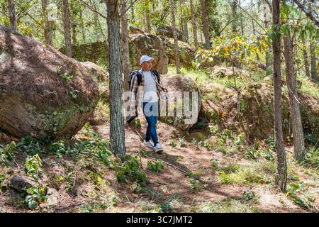 Male photographer exploring the forest, camera in hand and eyes focused on the landscape. Nature immersion and visual inspiration in a peaceful outdoo Stock Photo