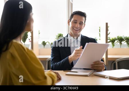 Businessman holds papers, conducting job interview or meeting in office Stock Photo