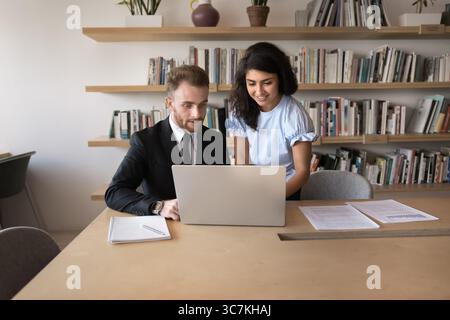 Two multiethnic colleagues collaborating on project in coworking Stock Photo