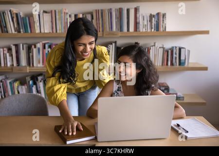 Two Indian women colleagues laughing during meeting in office Stock Photo