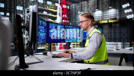 Young Caucasian Male SCADA Engineer Monitors Processes At Construction Site. Stock Photo