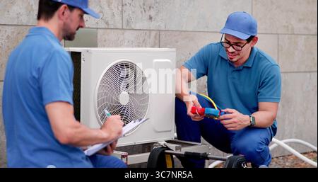 Experienced Hispanic Technician Installing Commercial HVAC System In Office Building. Stock Photo