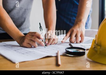 Close up hand of architect is designing using a blueprint for construction in the construction office Stock Photo