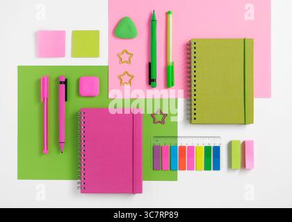 Knolling composition with different school stationery on pink and green background. Back to school Stock Photo