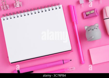 Empty notepad sheet with pink school and office stationery on magenta background. Eraser in form of cat. Flatly. Stock Photo