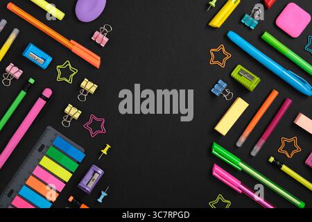 Knolling sationery background with colorful rainbow school and office stationery set on black background. Space for your text Stock Photo