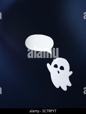 Friendly paper ghost with a bubble for text on an blue background Stock Photo