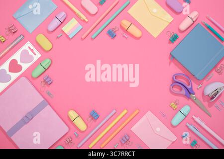 Frame of colorful school and office stationery set on pink background. Flatly, copyspace Stock Photo